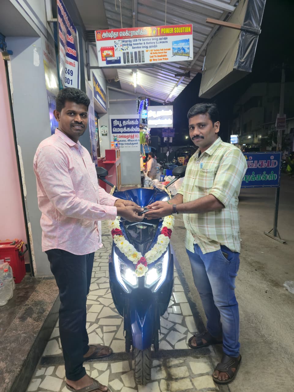 Happy customer receiving new scooter keys at PNT Power Solution