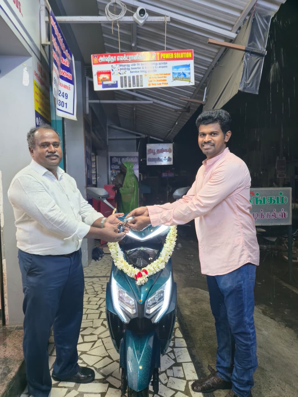 Customer taking delivery of new electric scooter at Arshitha Electronics