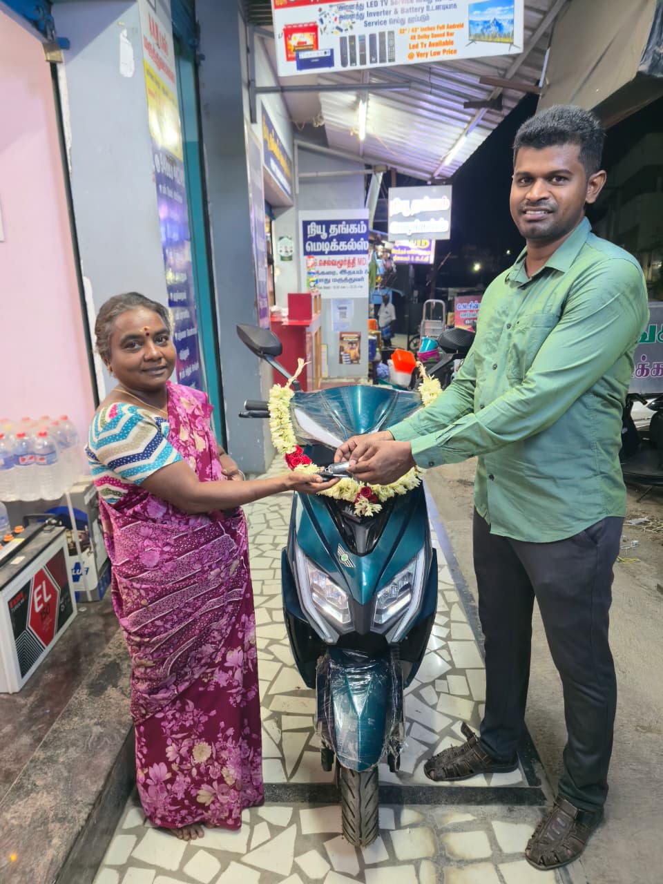 Customer receiving keys of new teal electric scooter