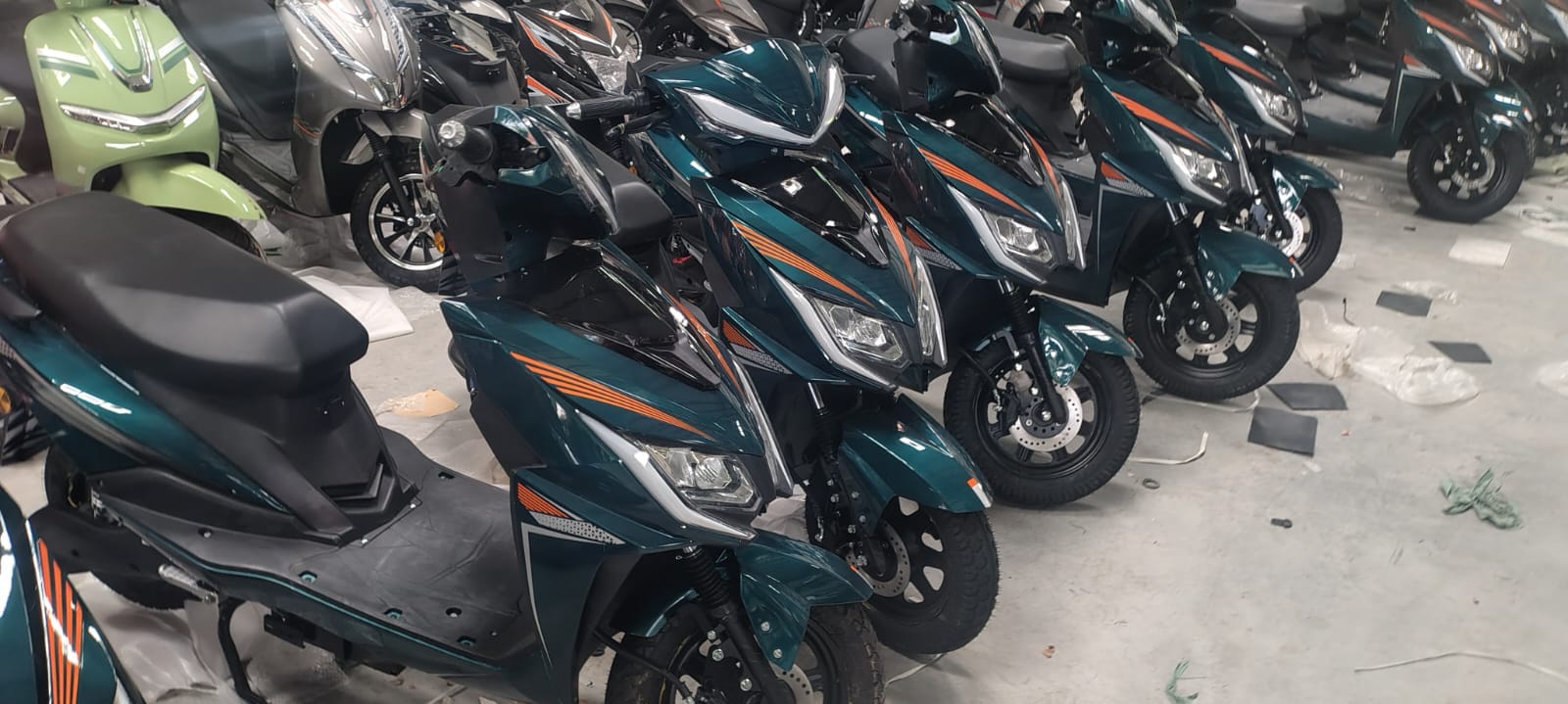Row of teal electric scooters with orange accents